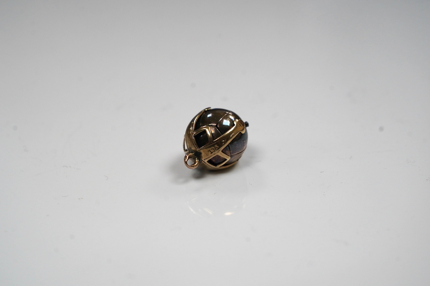 A yellow metal and white metal masonic ball pendant, the yellow metal stamped 9ct, 17mm. Condition - fair